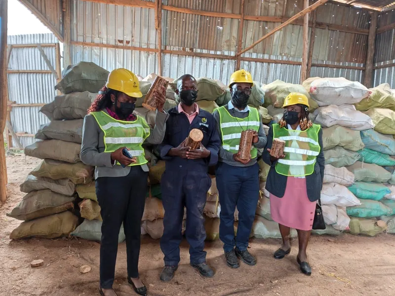 Utheri team in safety gear holding finished briquettes